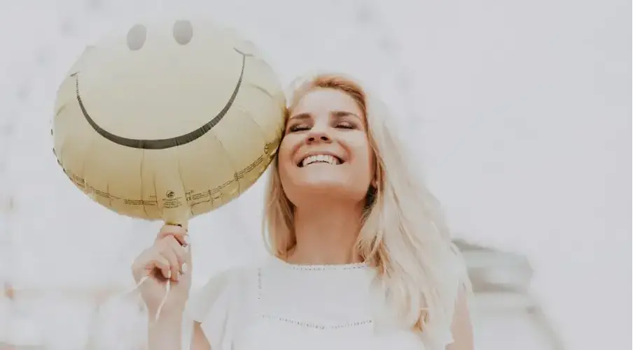 a woman smiling after getting ceramic veneers